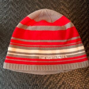 Unisex red North Face Knit Hat with fleece liner around ears.